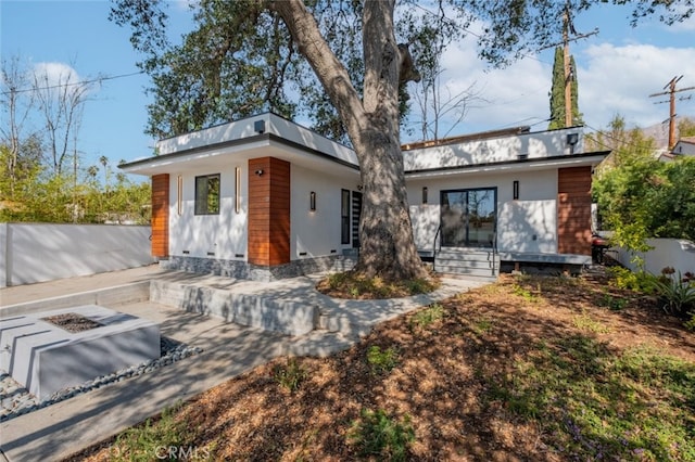 view of front of house with an outdoor fire pit and stucco siding