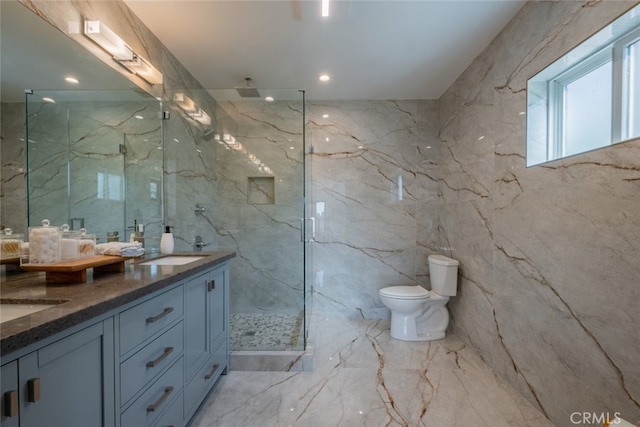 bathroom featuring double vanity, toilet, and stone wall