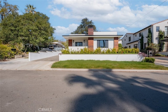 view of front of property featuring a chimney and stucco siding