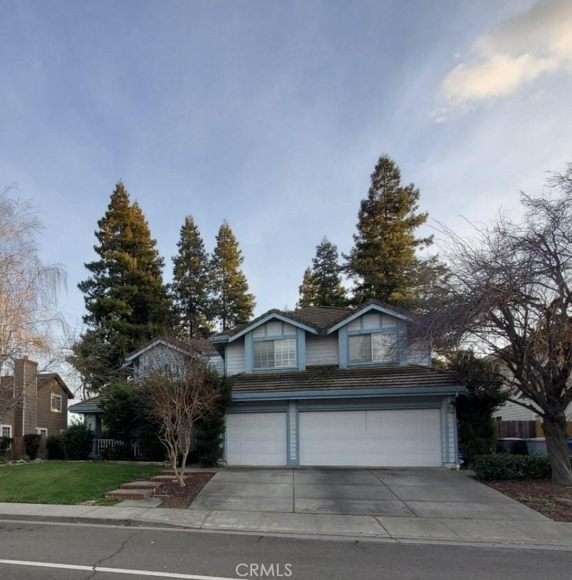 traditional-style house featuring a garage and concrete driveway