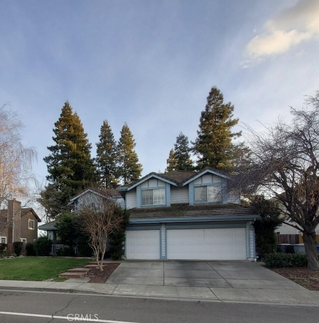 traditional-style house featuring a garage and concrete driveway