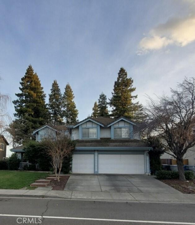 traditional home featuring concrete driveway and an attached garage