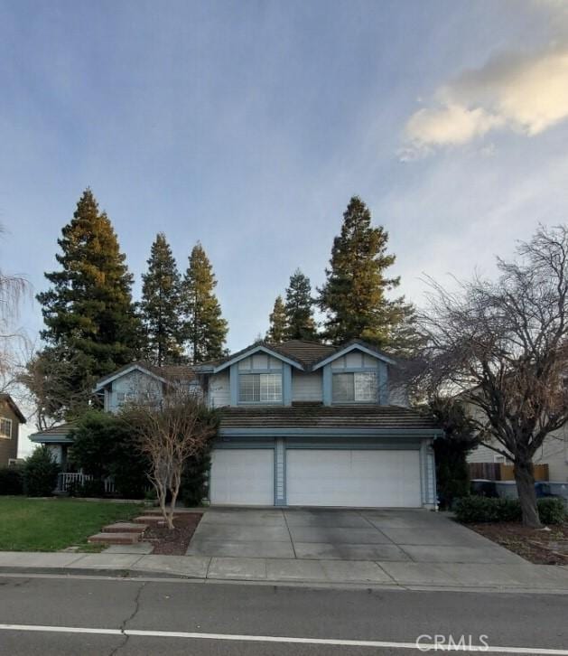 traditional home featuring concrete driveway and an attached garage