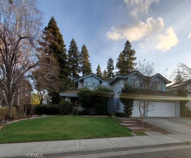 traditional-style house featuring a garage, driveway, and a front lawn