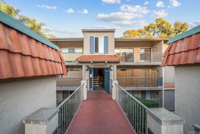 exterior space with a tile roof and stucco siding