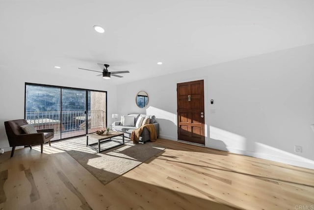 living area with a ceiling fan, recessed lighting, baseboards, and wood finished floors