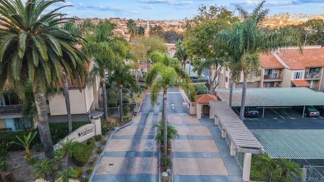 surrounding community with uncovered parking, a gate, and fence