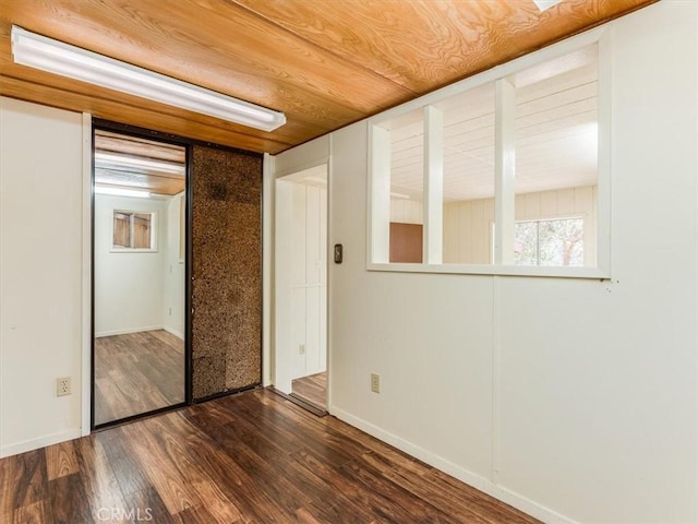 spare room with dark wood-style floors and wooden ceiling