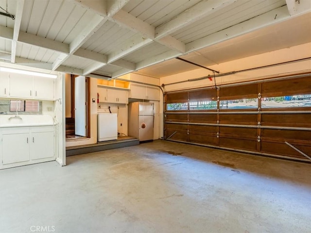 garage featuring washer / dryer and freestanding refrigerator