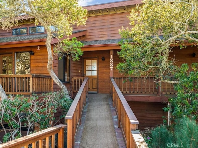 exterior space with a porch and a shingled roof