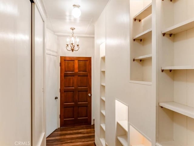 doorway to outside with dark wood-style floors and an inviting chandelier