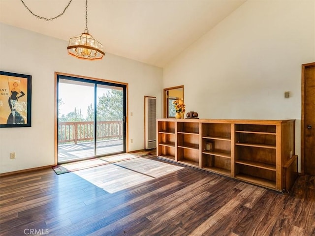 interior space with dark wood-style floors, high vaulted ceiling, and baseboards