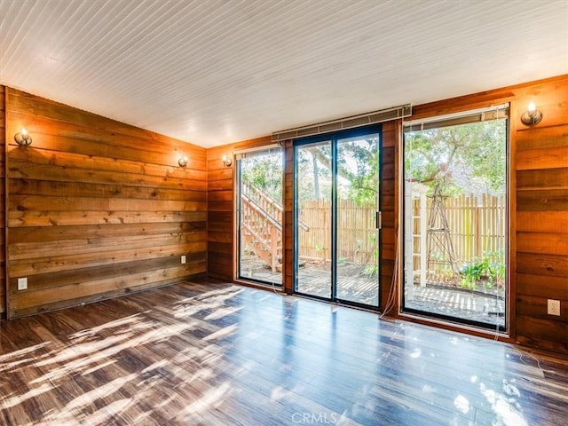 empty room featuring wooden walls and wood finished floors