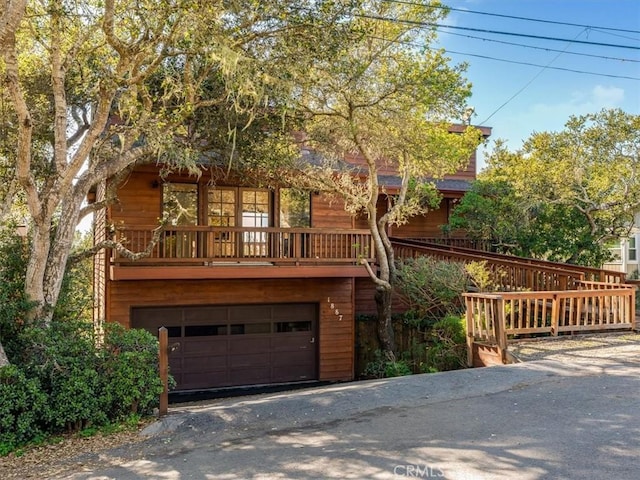 chalet / cabin with aphalt driveway and an attached garage