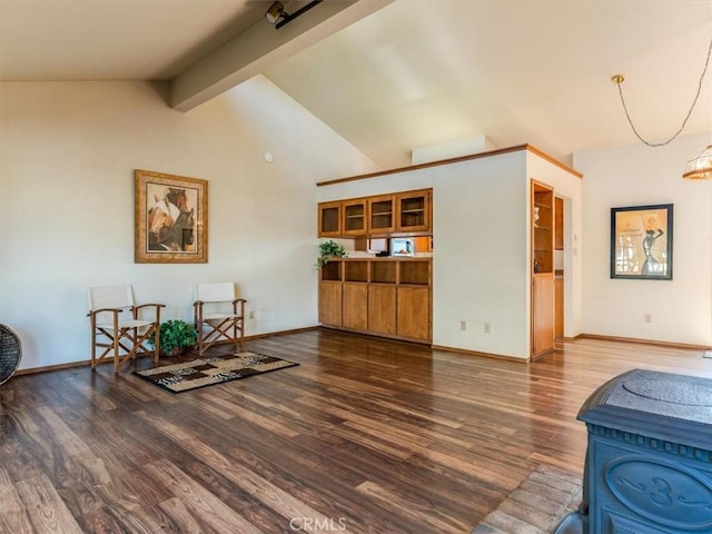 living area featuring lofted ceiling with beams, dark wood-type flooring, and baseboards