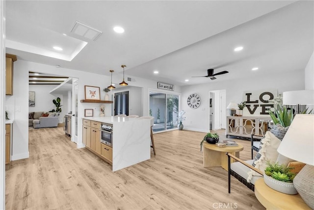 kitchen with light wood-type flooring, recessed lighting, light countertops, and oven