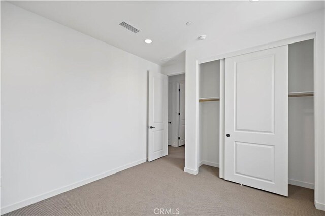 unfurnished bedroom featuring baseboards, visible vents, light colored carpet, a closet, and recessed lighting