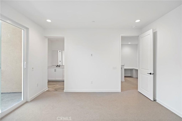 unfurnished bedroom with light carpet, baseboards, and recessed lighting