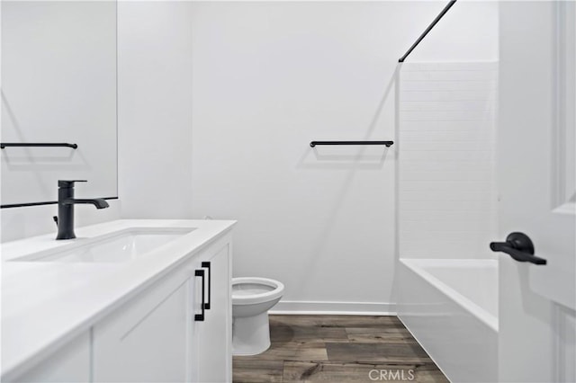 full bathroom featuring baseboards, vanity, toilet, and wood finished floors