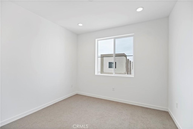 empty room with recessed lighting, light carpet, and baseboards