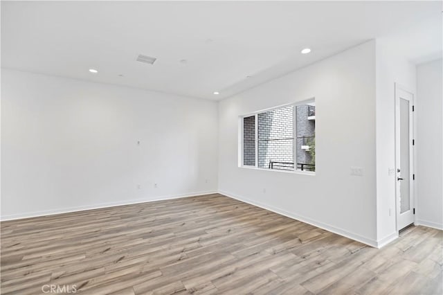 empty room with recessed lighting, visible vents, light wood-style flooring, and baseboards