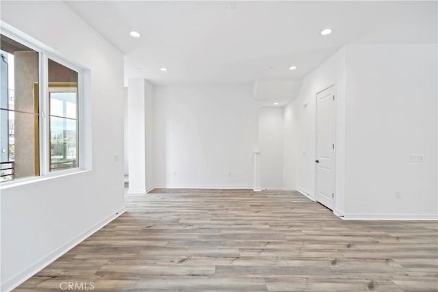 unfurnished room with recessed lighting, baseboards, and wood finished floors