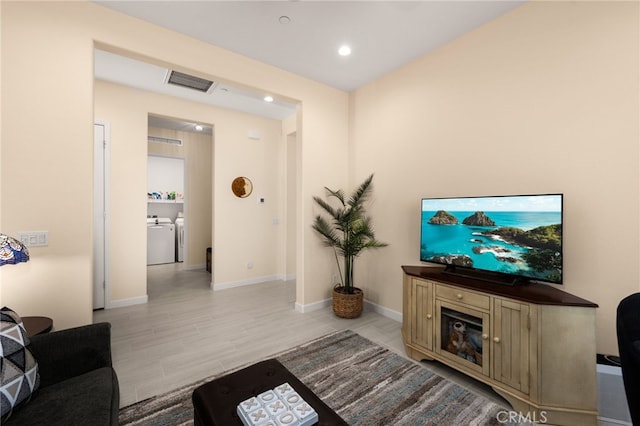 living room featuring visible vents, baseboards, recessed lighting, separate washer and dryer, and light wood-type flooring