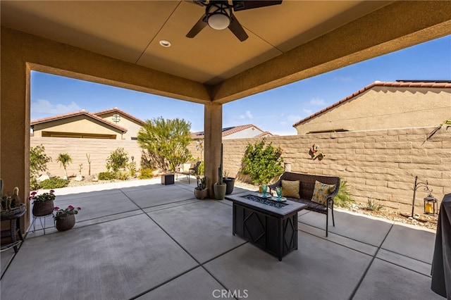 view of patio with ceiling fan, a fire pit, and a fenced backyard