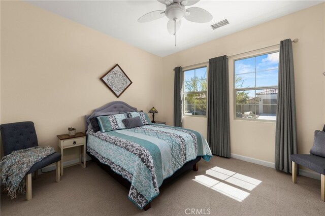 bedroom with visible vents, light carpet, baseboards, and a ceiling fan