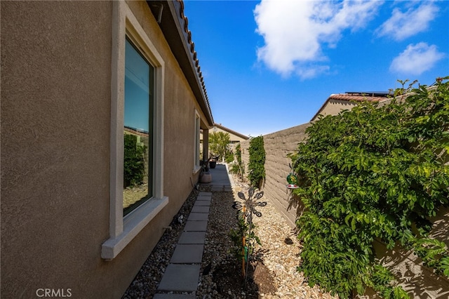 view of home's exterior with fence and stucco siding