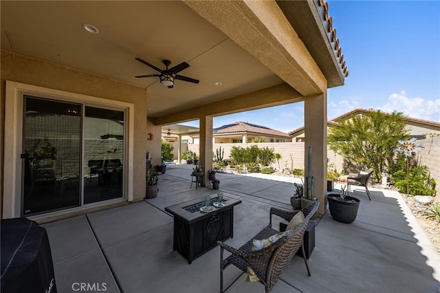 view of patio featuring ceiling fan, an outdoor fire pit, and a fenced backyard