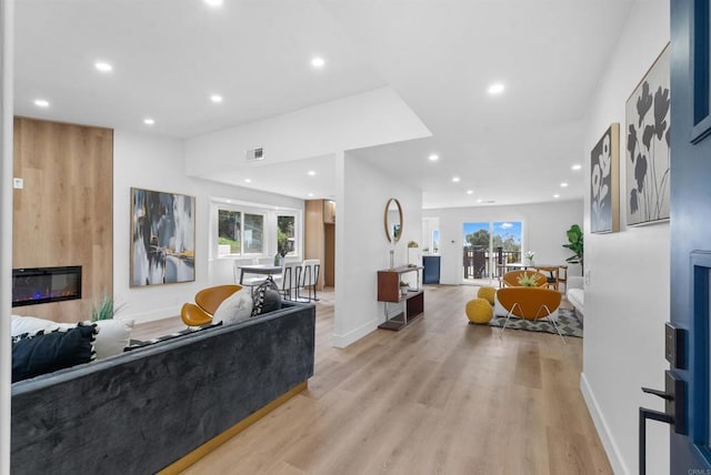 living area featuring recessed lighting, a large fireplace, visible vents, and light wood finished floors