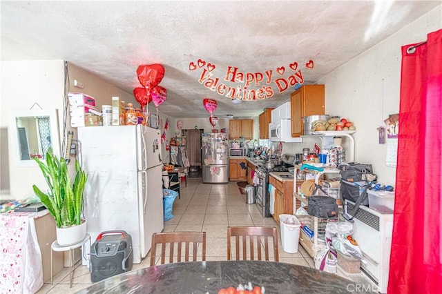 kitchen featuring brown cabinets, stainless steel appliances, and light tile patterned flooring