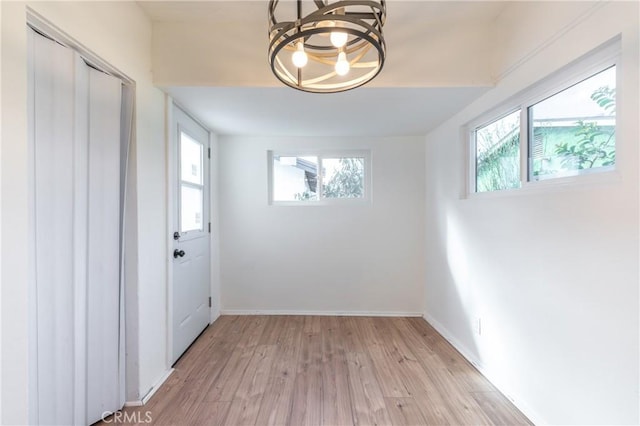 entryway with a healthy amount of sunlight, light wood-style floors, and baseboards