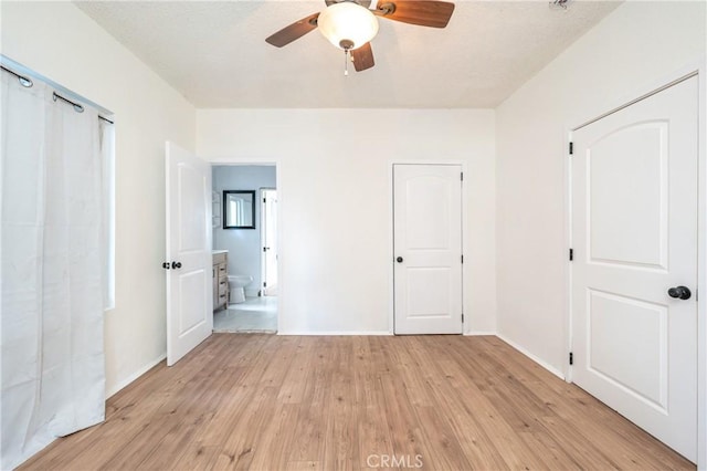 unfurnished bedroom with ensuite bath, light wood-style flooring, baseboards, and a ceiling fan