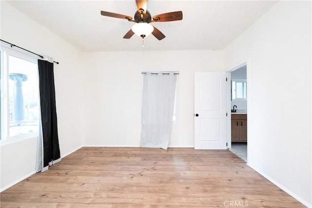 empty room with a ceiling fan and light wood-type flooring