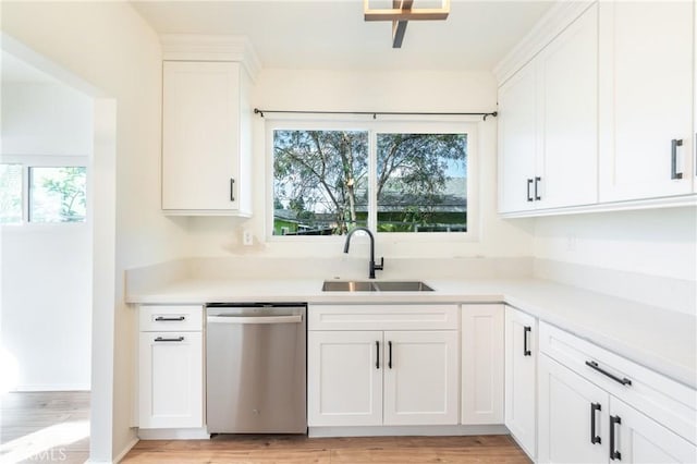 kitchen with a sink, a healthy amount of sunlight, white cabinets, and dishwasher