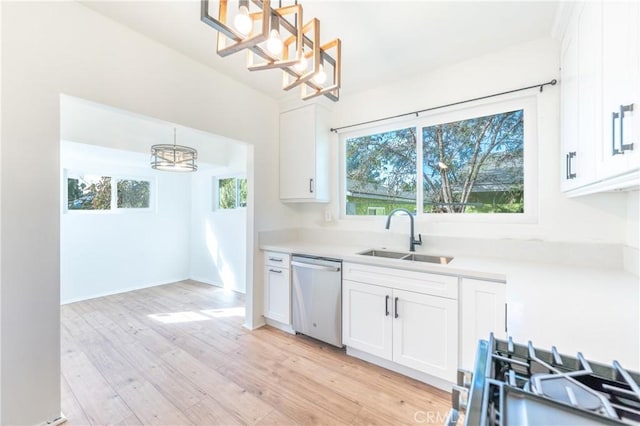 kitchen featuring a wealth of natural light, white cabinets, dishwasher, and a sink