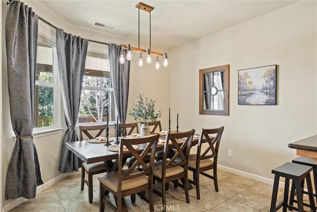 dining space featuring light tile patterned floors, visible vents, and baseboards