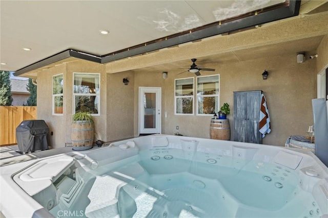 view of patio / terrace with a ceiling fan, fence, washer / clothes dryer, a hot tub, and a grill