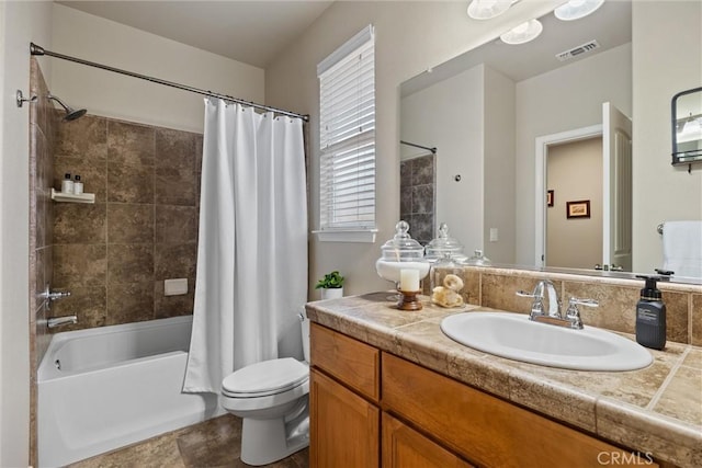 full bathroom featuring visible vents, toilet, vanity, and shower / bathtub combination with curtain