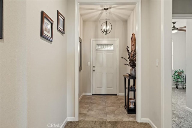 entryway with a chandelier, light carpet, and baseboards