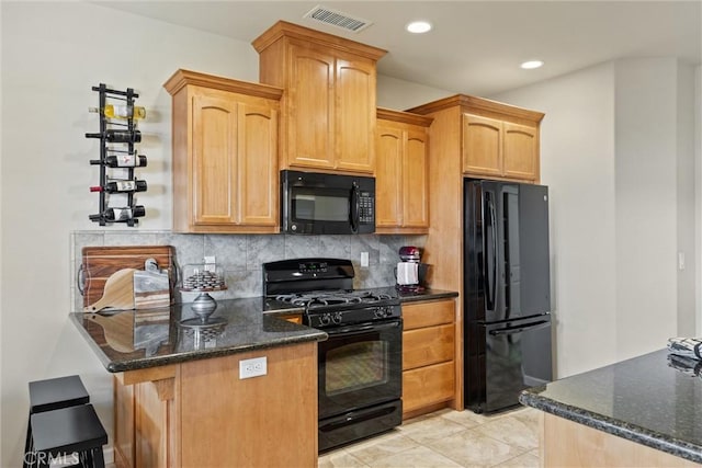 kitchen featuring dark stone countertops, visible vents, a peninsula, black appliances, and backsplash