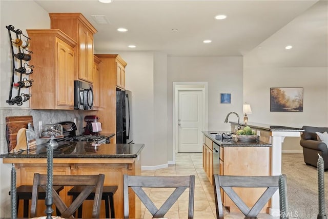 kitchen featuring black appliances, a sink, backsplash, recessed lighting, and a peninsula