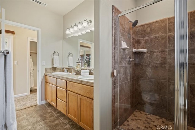 bathroom with double vanity, visible vents, a shower stall, and a sink