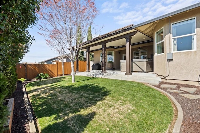 view of yard featuring a patio, a jacuzzi, and a fenced backyard