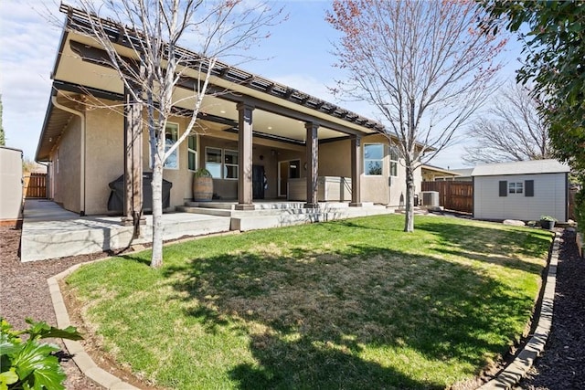 back of house with a patio area, stucco siding, an outbuilding, and fence