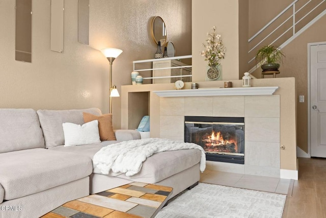 living room with wood finished floors and a tile fireplace