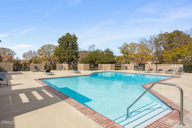 community pool featuring a patio and fence