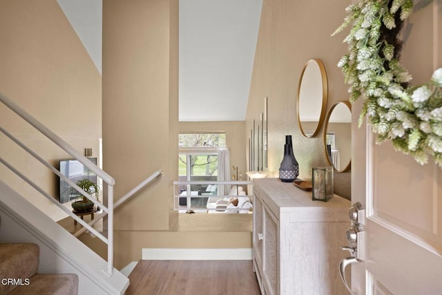 entryway with a towering ceiling and wood finished floors